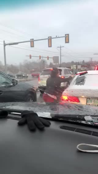 Driver stopped in traffic jumps out to clean stranger's windshield