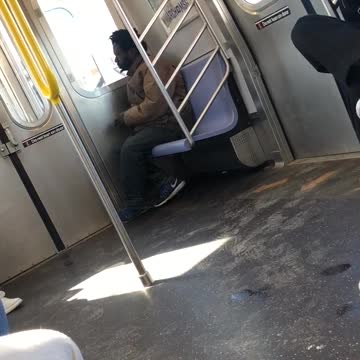 Man lights up a cigarette inside subway train