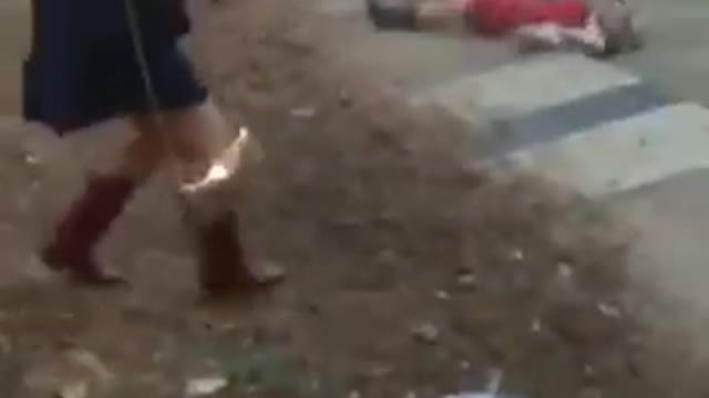 Girl in red dress stumbles backwards and falls down