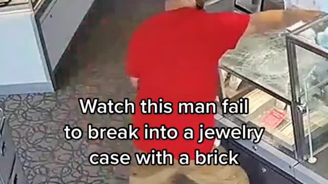 Watch this man fail to break into a jewelry case with a brick