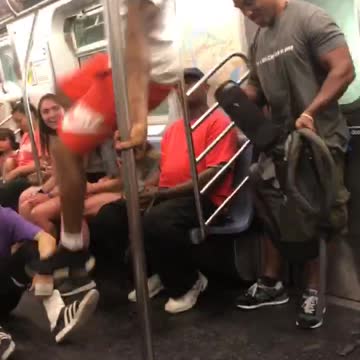 Guy white shirt red shorts dancing hanging subway train