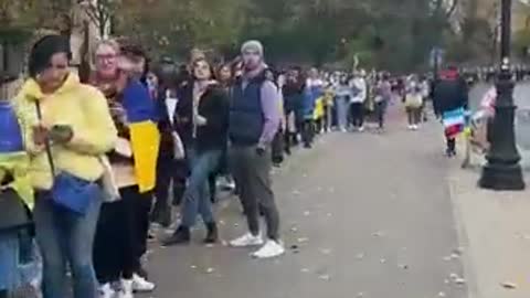 A group of polish gathered with Ukrainian flags and posters