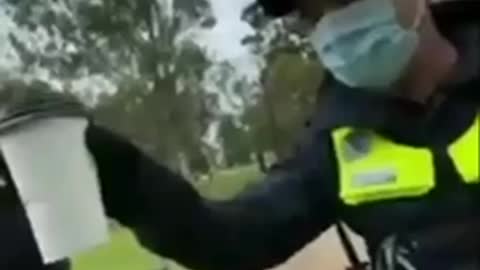 Australian policeman checking if cup is empty to validate mask exemption.