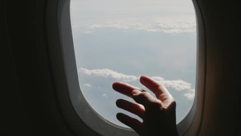 A Person Touching the Window in the Airplane