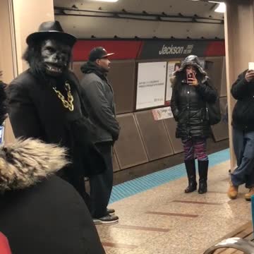 Guy dressed in gorilla tuxedo suit dances in subway station