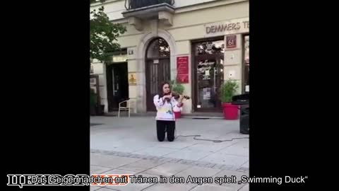 Eine Geigerin mit Tränen in den Augen spielt Plywe kacha im Zentrum von Warschau