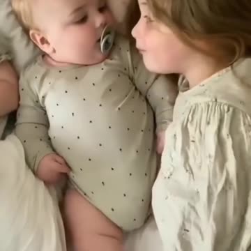 Beautiful scene of sisters taking care of little brother while he sleeps
