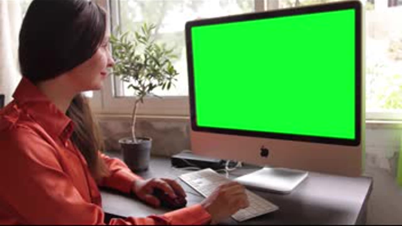 Woman Using Computer With Green Screen Display. Free stock footage