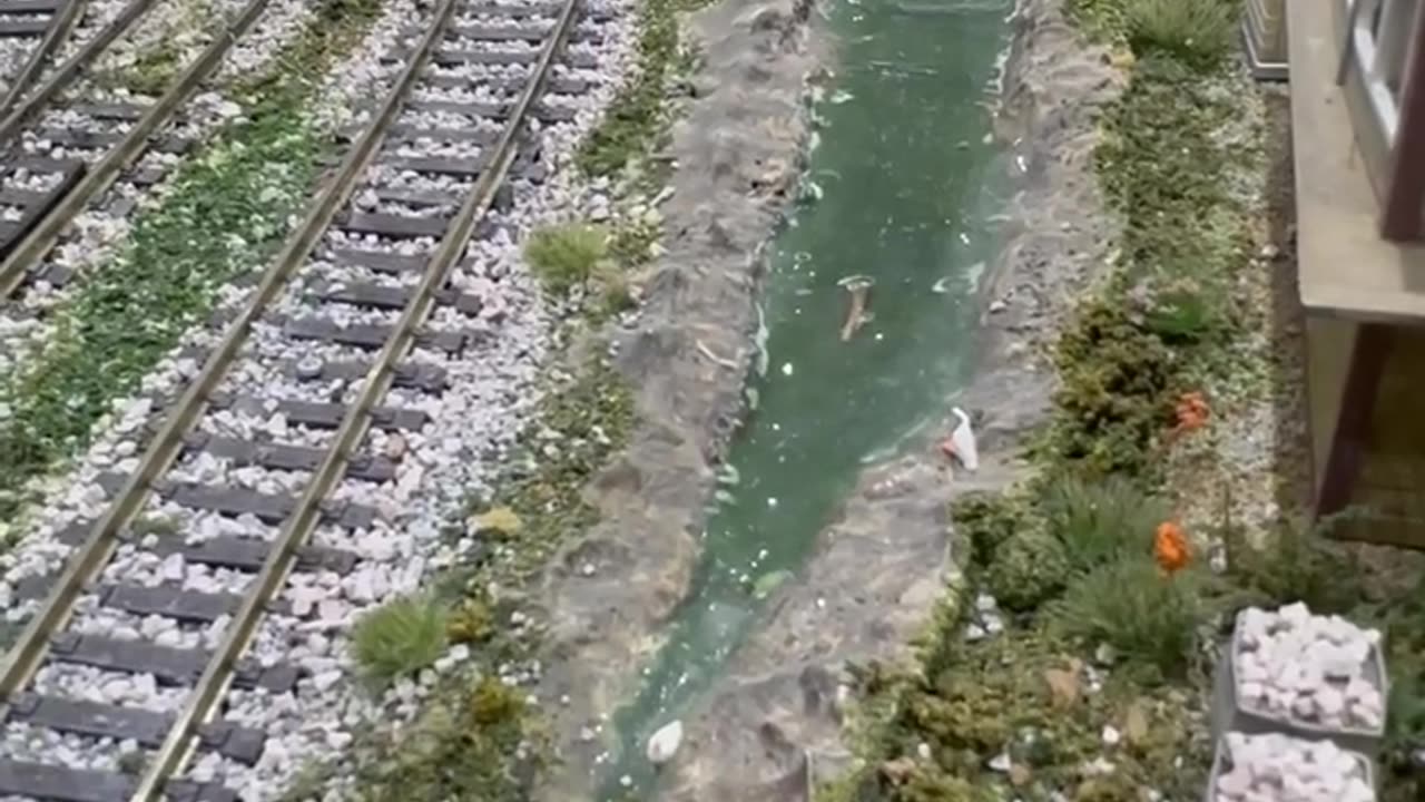 Class 85 ambles past the stream.