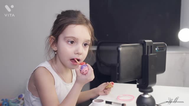 The baby applying lipstick for her smartness