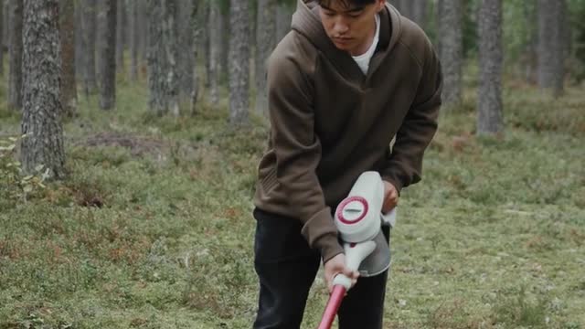 Man using Vacuum Cleaner in Forest