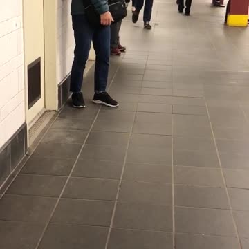 Older woman blue coats bangs shoulder against subway wall