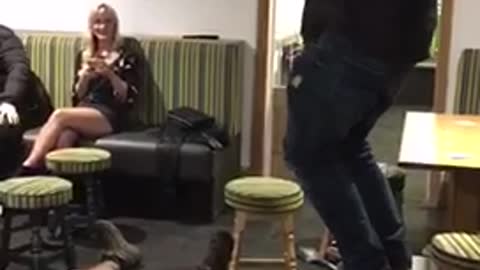 Guy blue sweater tries jumping on seats and falls