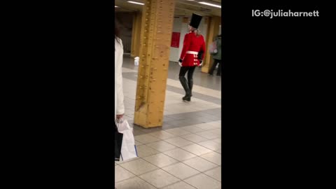 Man in red british guard outfit subway