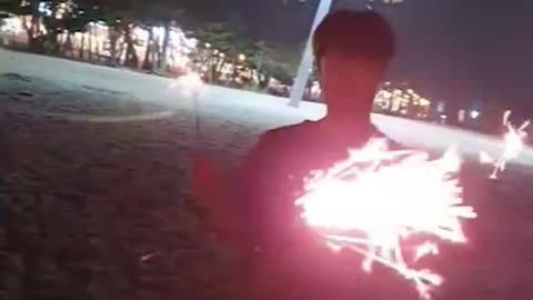 Many men are enjoying a firecracker at the beach in Korea.