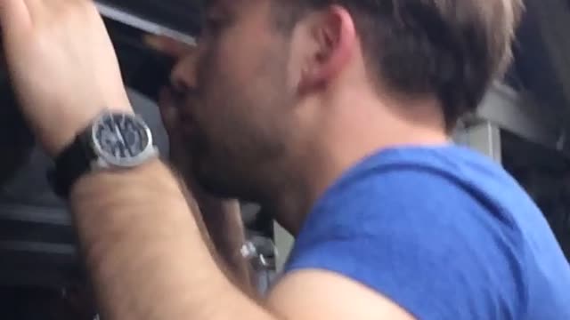 Man in blue on train throws up outside window