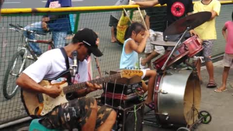 A STREET DRUMMER LITTLE GIRL PERFORMING