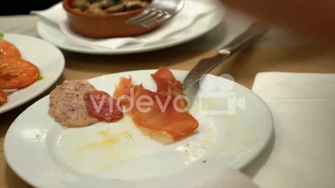 Lonely young man eating salami and meat aperitivo with bread at the restaurant