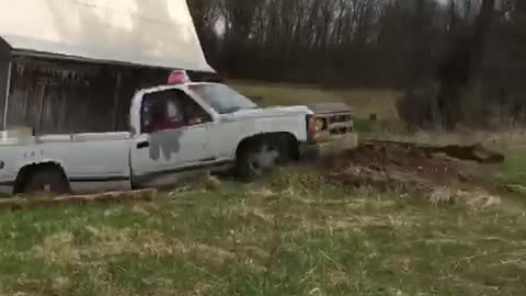 White pick up truck goes up dirt ramp