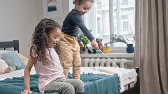 Two Quiet Girls Booth Playing Catch The Bait With Their Cat In The Bedroom.