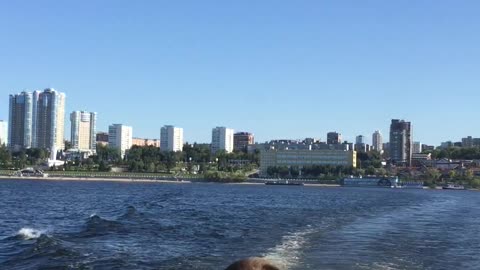 Young man’s boat ride on the Volga river with a beautiful view