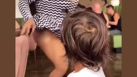 A parent teaches their toddler to tip a drag queen