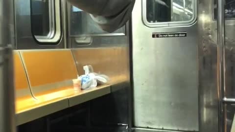A man hanging onto ceiling of train