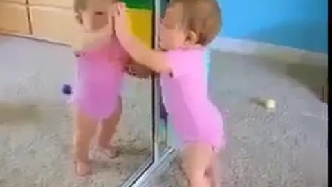 A child watches himself for the first time in the mirror