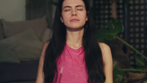 Young woman meditating with incense