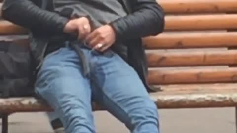 Nsfw guy peeing while sitting down on brown bench