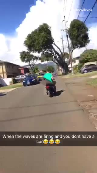 Man in green carrying surf board on moped