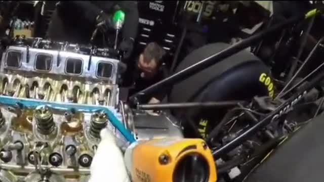 A mechanic works on a large engine