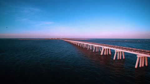 DRONE FOOTAGE OF A BRIDGE ON THE OCEAN