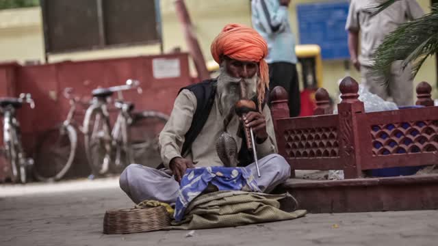 Male Indian street snake charmers play a flute