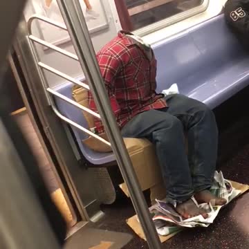 Headless red shirt guy rides subway someone takes picture of him