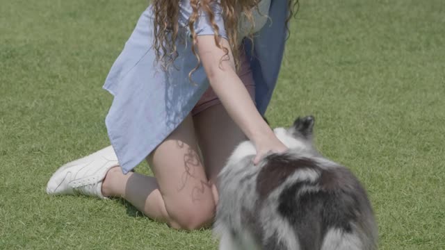 A woman petting her dog, part 1