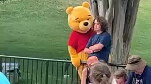 Winnie the Pooh's mascot sneaks up on an unsuspecting man