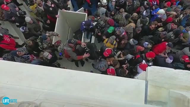 Black-clad people smashing at Capitol, regular marchers try to stop them