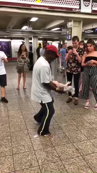 Man dancing with toy doll in subway station