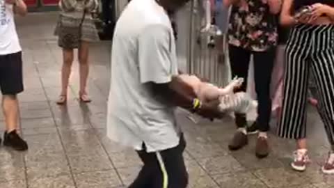 Man dancing with toy doll in subway station