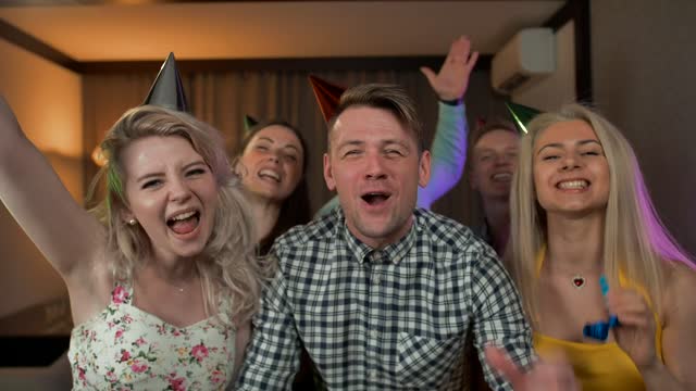 Excited young people partying with party hats