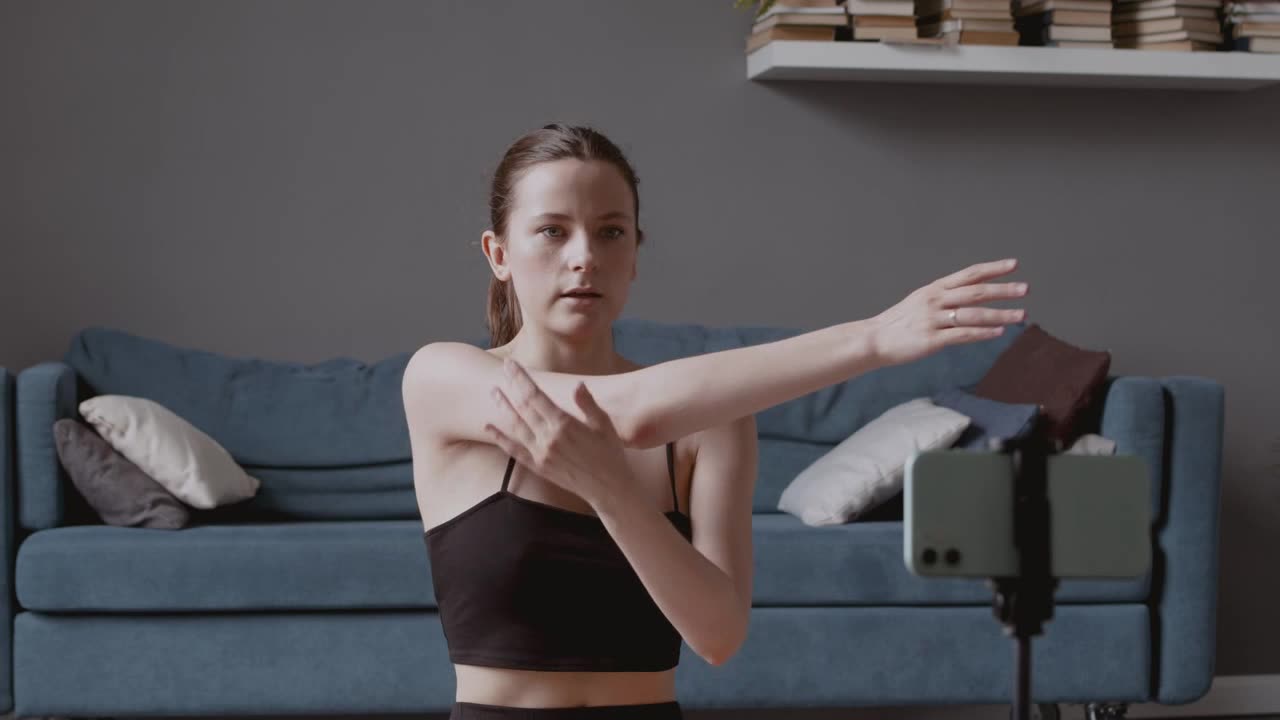 Young influencer woman recording a yoga lesson with her smartphone camera