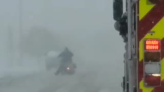 Firetruck Escorts Motorcycle Through the Snow