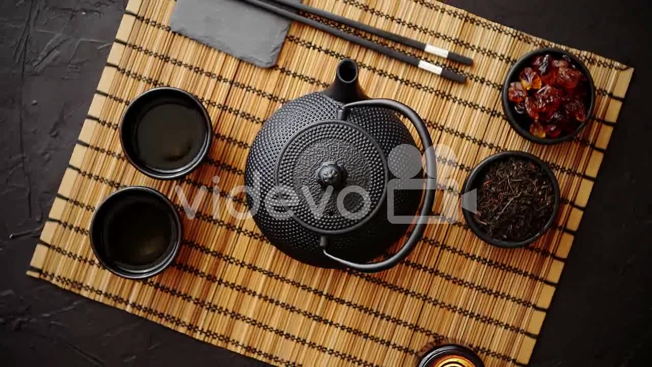 Asian green tea set on bamboo mat-Asian green tea set on bamboo mat with dried green tea