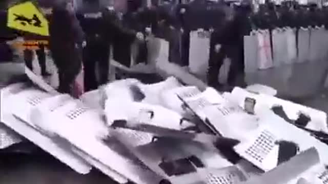 Police line throwing down their riot shields - UKRAINE?