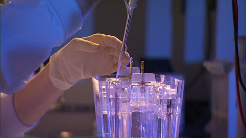 lab worker carefully samples a solution in a laboratory.