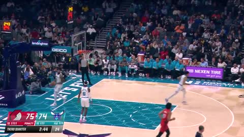 Logo Lillard hits from the Spectrum Center writing in front of the #Hornets bench.