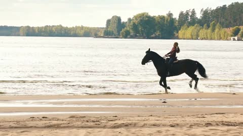 girl riding a horse along the coast