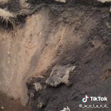A Ukrainian soldier shows a huge crater from the arrival of something very heavy,