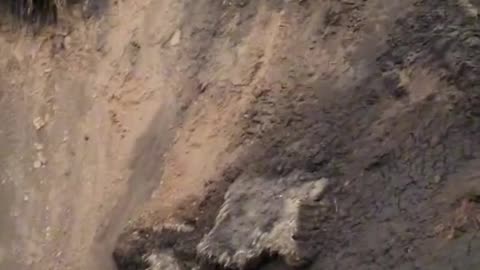 A Ukrainian soldier shows a huge crater from the arrival of something very heavy,